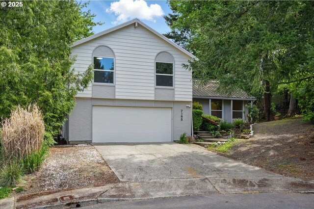 tri-level home with a garage and concrete driveway