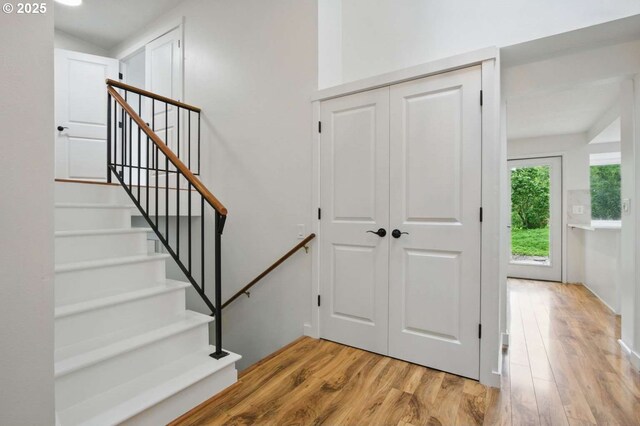 staircase featuring wood finished floors and baseboards