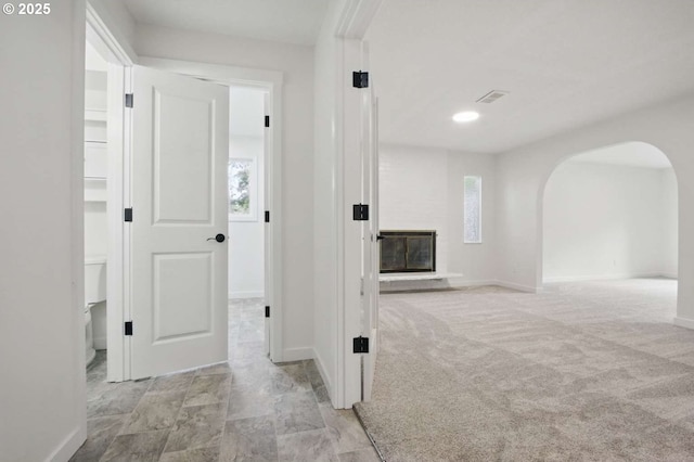 corridor featuring arched walkways and baseboards