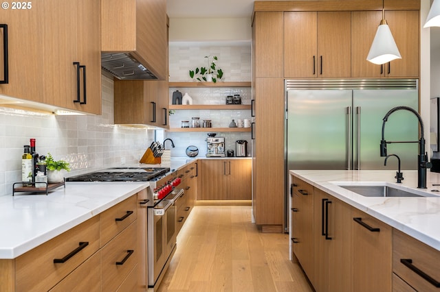 480 W U St, Washougal, WA 98671 - kitchen with range with two ovens, custom exhaust hood, light wood-style floors, open shelves, and light stone counters