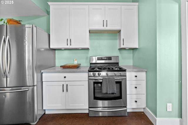 kitchen with stainless steel appliances, light countertops, white cabinets, and baseboards