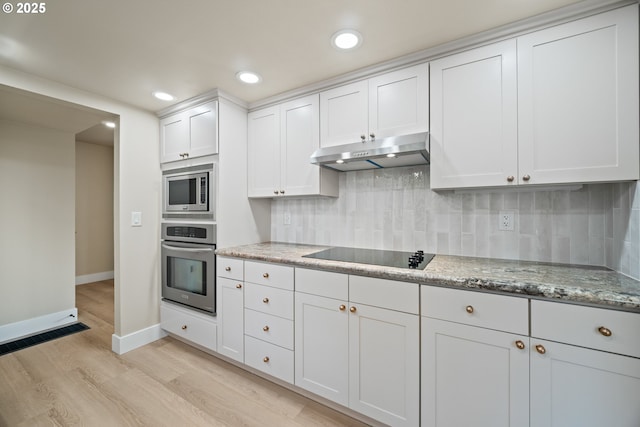 kitchen with light stone countertops, stainless steel appliances, tasteful backsplash, light hardwood / wood-style flooring, and white cabinets