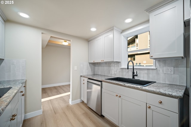 kitchen with white cabinets, dishwasher, and light stone counters