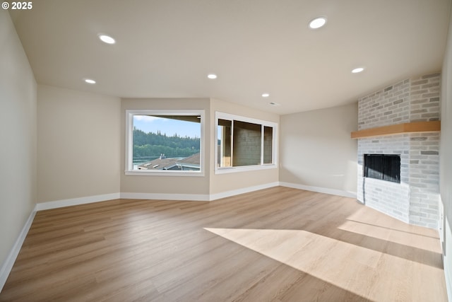 unfurnished living room featuring a fireplace and light hardwood / wood-style flooring