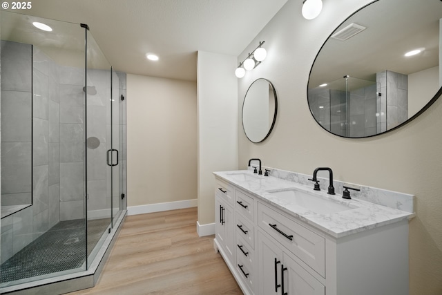 bathroom featuring vanity, a shower with shower door, and hardwood / wood-style flooring