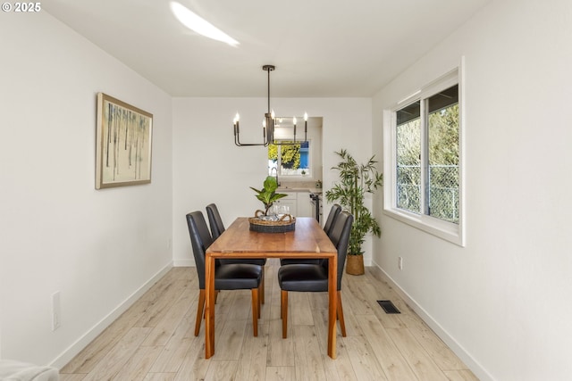 dining area featuring an inviting chandelier and light hardwood / wood-style flooring