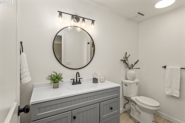 bathroom with vanity, wood-type flooring, and toilet