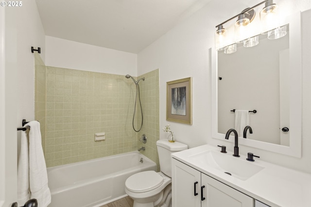 full bathroom featuring tiled shower / bath, vanity, and toilet