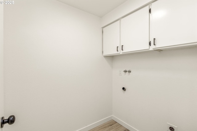 washroom with cabinets, electric dryer hookup, hookup for a washing machine, and light hardwood / wood-style flooring