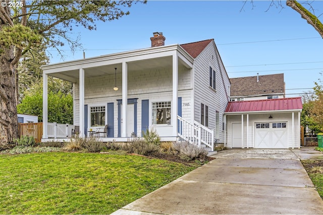 view of front facade with a chimney, covered porch, metal roof, driveway, and a front lawn