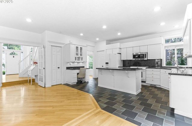 16800 NW Paddington Dr, Beaverton, OR 97006 - kitchen featuring white appliances, white cabinets, a center island, recessed lighting, and dark countertops