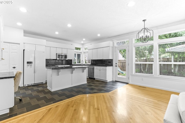 16800 NW Paddington Dr, Beaverton, OR 97006 - kitchen with appliances with stainless steel finishes, white cabinets, dark countertops, recessed lighting, and decorative backsplash
