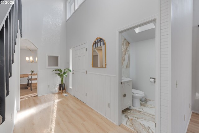 interior space featuring toilet, a chandelier, and hardwood / wood-style floors