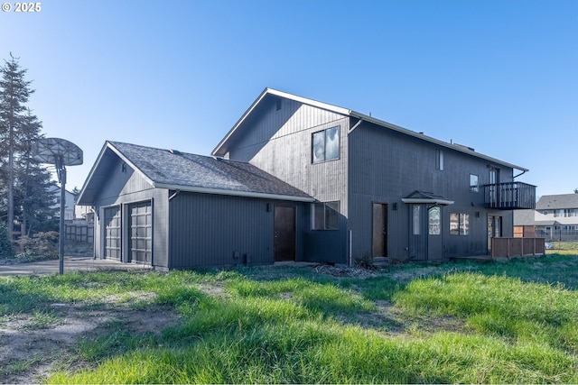 back of property with a garage and a balcony