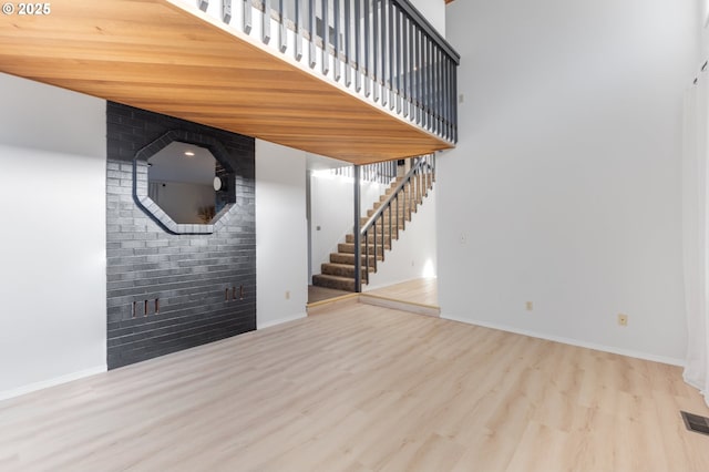 interior space featuring a towering ceiling and light hardwood / wood-style floors