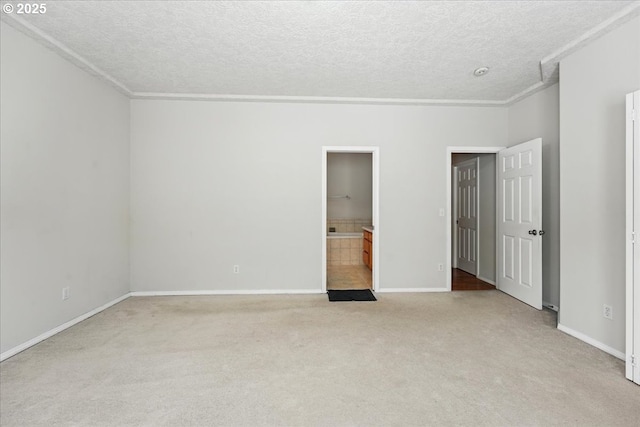 unfurnished bedroom featuring light carpet, a textured ceiling, ornamental molding, and baseboards