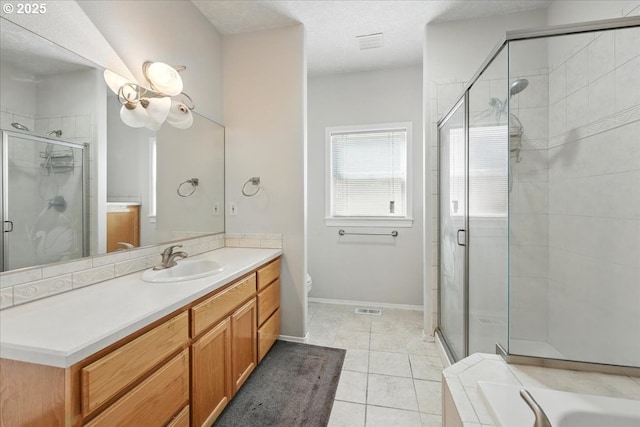 full bath with a stall shower, vanity, tile patterned floors, baseboards, and toilet