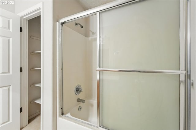 bathroom featuring combined bath / shower with glass door