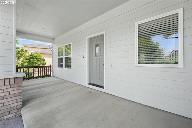 view of exterior entry featuring covered porch