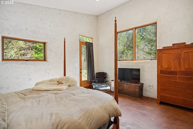 bedroom featuring concrete flooring and access to outside