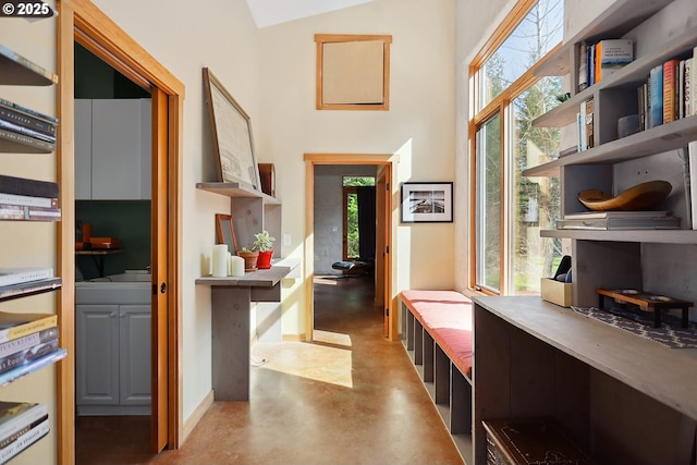 hall with concrete flooring and a high ceiling