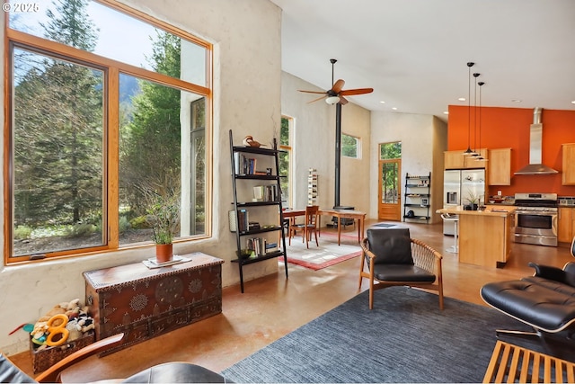 living room featuring plenty of natural light, ceiling fan, a high ceiling, and recessed lighting