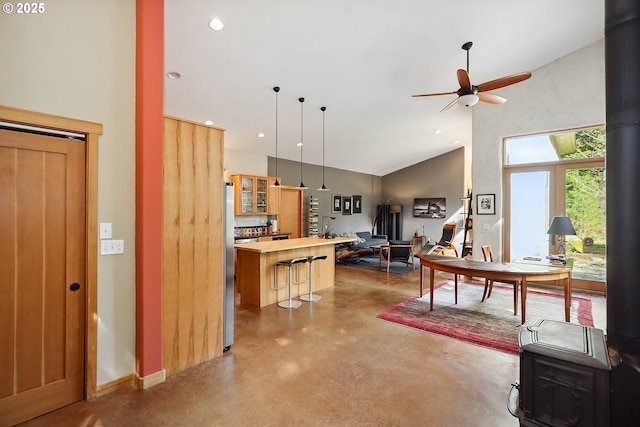 kitchen featuring concrete floors, high vaulted ceiling, a ceiling fan, glass insert cabinets, and a kitchen island
