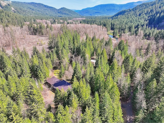 view from above of property with a forest and a mountainous background