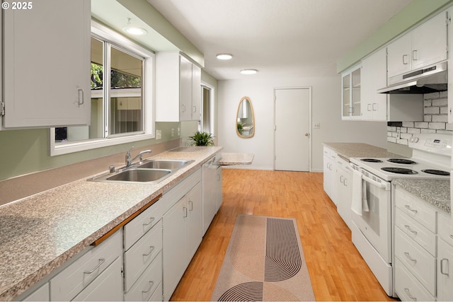 kitchen featuring white appliances, under cabinet range hood, a sink, white cabinetry, and light countertops