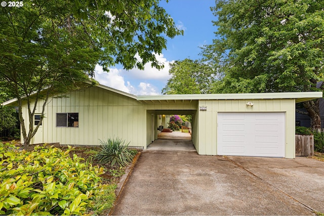 view of front of property featuring concrete driveway, board and batten siding, an attached garage, and a carport