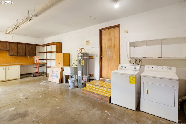 garage featuring independent washer and dryer, water heater, and a sink