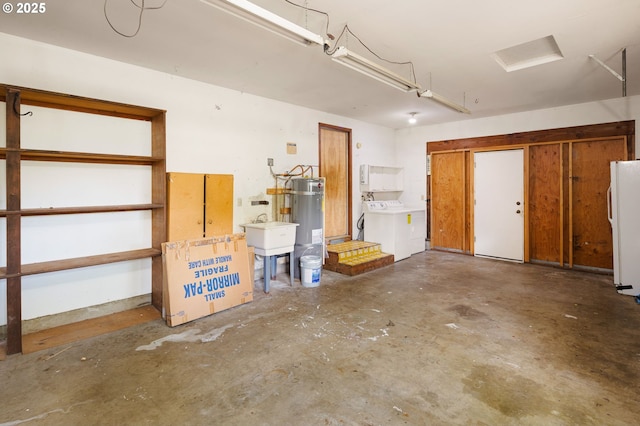 garage featuring strapped water heater, freestanding refrigerator, and washing machine and clothes dryer