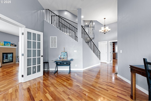 1155 Holly Ave, Cottage Grove, OR 97424 - foyer entrance featuring light wood-style floors, a towering ceiling, a chandelier, and a fireplace
