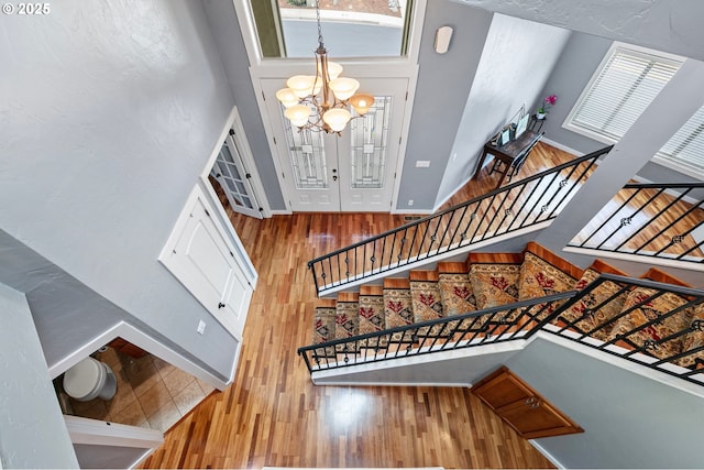 1155 Holly Ave, Cottage Grove, OR 97424 - stairway featuring a chandelier, wood finished floors, a towering ceiling, and plenty of natural light
