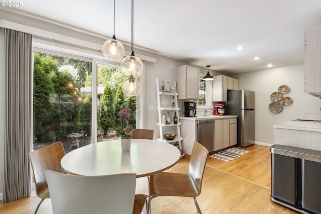 dining space with healthy amount of natural light, light wood-type flooring, and recessed lighting