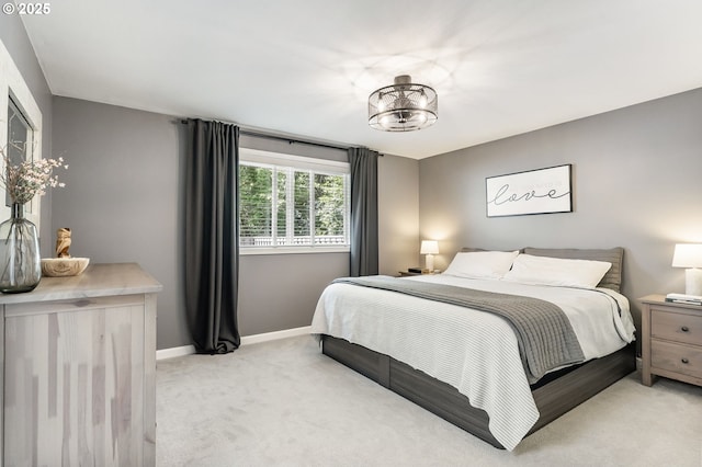 bedroom with light carpet and baseboards
