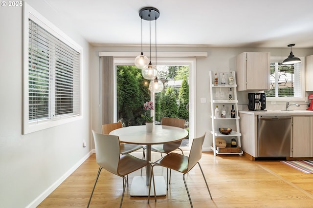 dining space with light wood finished floors and baseboards