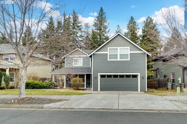 traditional-style home with a garage, concrete driveway, and fence