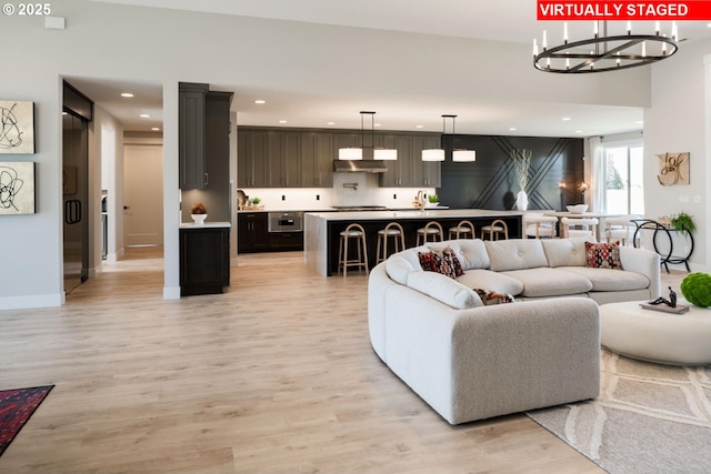 living area featuring light wood-type flooring, baseboards, and recessed lighting