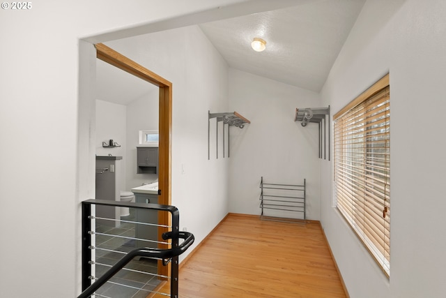 hallway featuring vaulted ceiling and wood finished floors