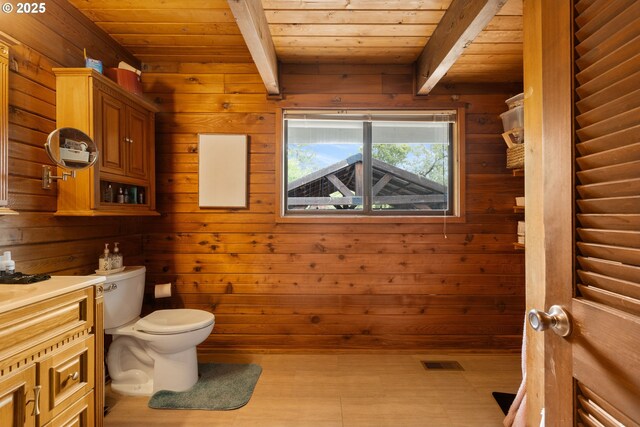 596 Sable Dr, Roseburg, OR 97470 - half bathroom with wood ceiling, toilet, wooden walls, beam ceiling, and vanity