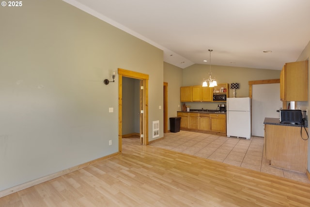 596 Sable Dr, Roseburg, OR 97470 - kitchen with freestanding refrigerator, dark countertops, black microwave, a chandelier, and vaulted ceiling