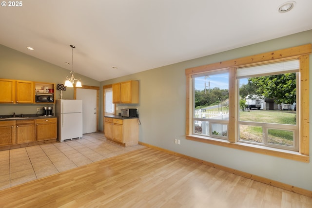 596 Sable Dr, Roseburg, OR 97470 - kitchen with freestanding refrigerator, black microwave, dark countertops, stainless steel microwave, and light wood-style flooring