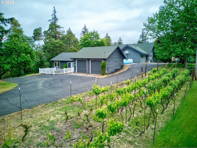 596 Sable Dr, Roseburg, OR 97470 - view of front of home with an attached garage, asphalt driveway, fence, and a garden