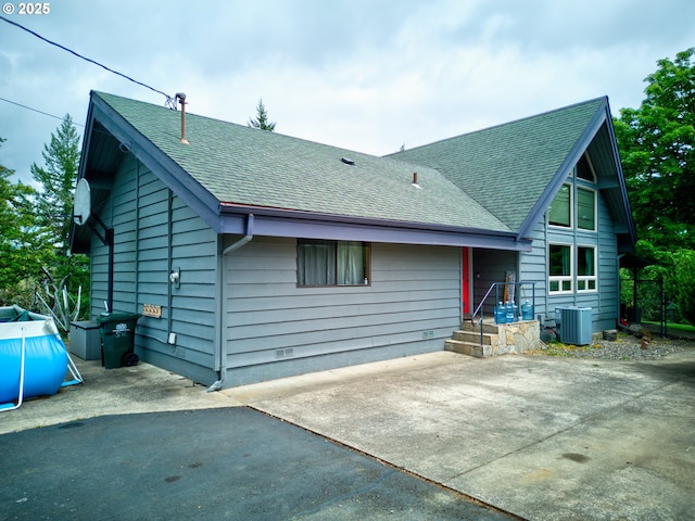 596 Sable Dr, Roseburg, OR 97470 - back of property with roof with shingles, central air condition unit, and a patio