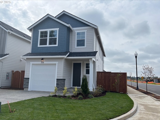 traditional-style house featuring an attached garage, a front yard, fence, and driveway