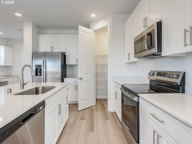 532 SW 23rd St, Battle Ground, WA 98604 - kitchen featuring appliances with stainless steel finishes, a sink, light wood-style floors, white cabinets, and recessed lighting
