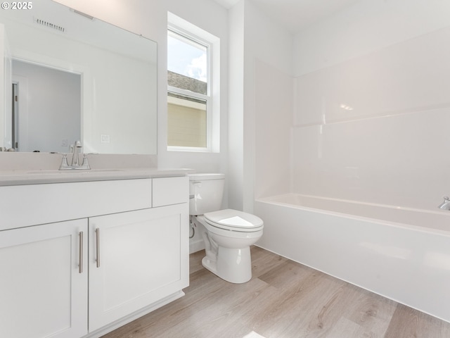 532 SW 23rd St, Battle Ground, WA 98604 - bathroom featuring wood finished floors, toilet, vanity, and bathing tub / shower combination