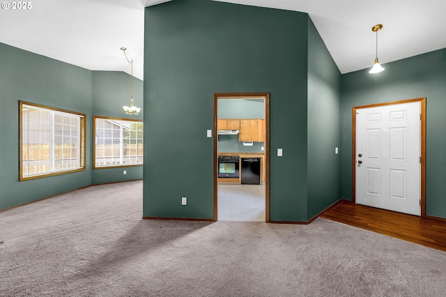 carpeted entryway with a notable chandelier, high vaulted ceiling, and baseboards