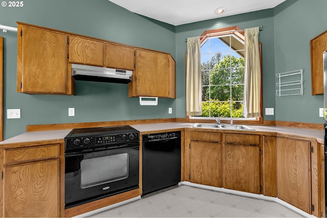 kitchen featuring a sink, under cabinet range hood, black appliances, light countertops, and light floors